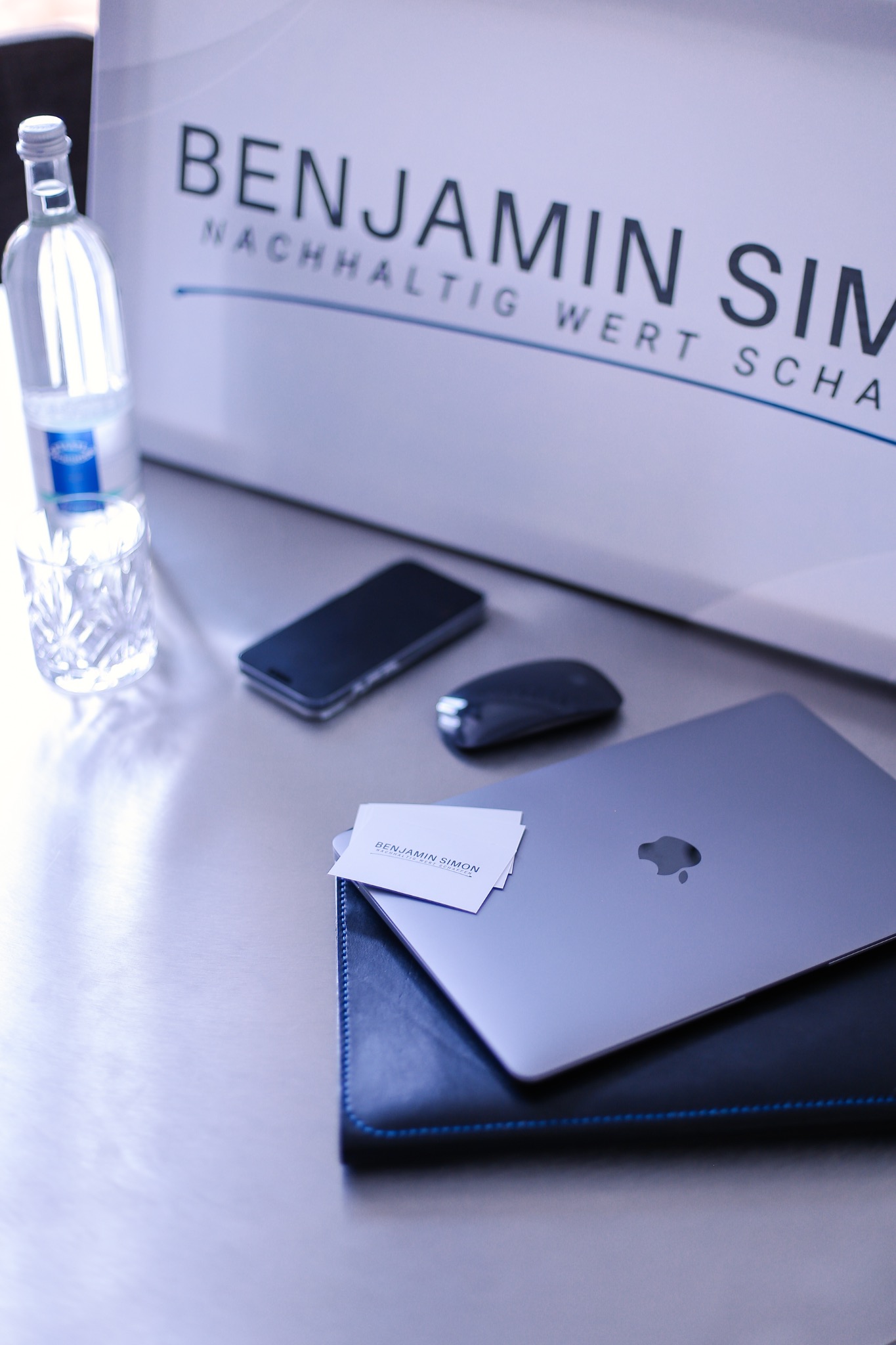 Arbeitsplatz von Benjamin Simon mit Laptop, Unterlagen und Geschäftsausstattung